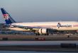 A blue-tailed Amerijet cargo jet moves on the ground at an airport.