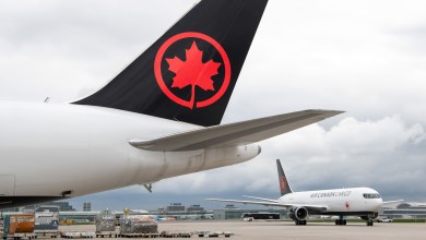 Close-up of red maple leaf logo on an Air Canada Cargo jet and another cargo jet in the background.