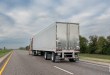 A tractor trailer driving down the highway