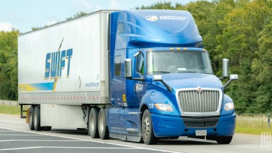 A blue Swift Transportation tractor pulling a Swift trailer on a highway