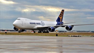 A Kuehne+Nagel 747 freighter is seen on a tarmac on a cloudy day.