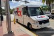 A FedEx van parked at a street corner in Miami Beach on a sunny day, with palm tree in the background.
