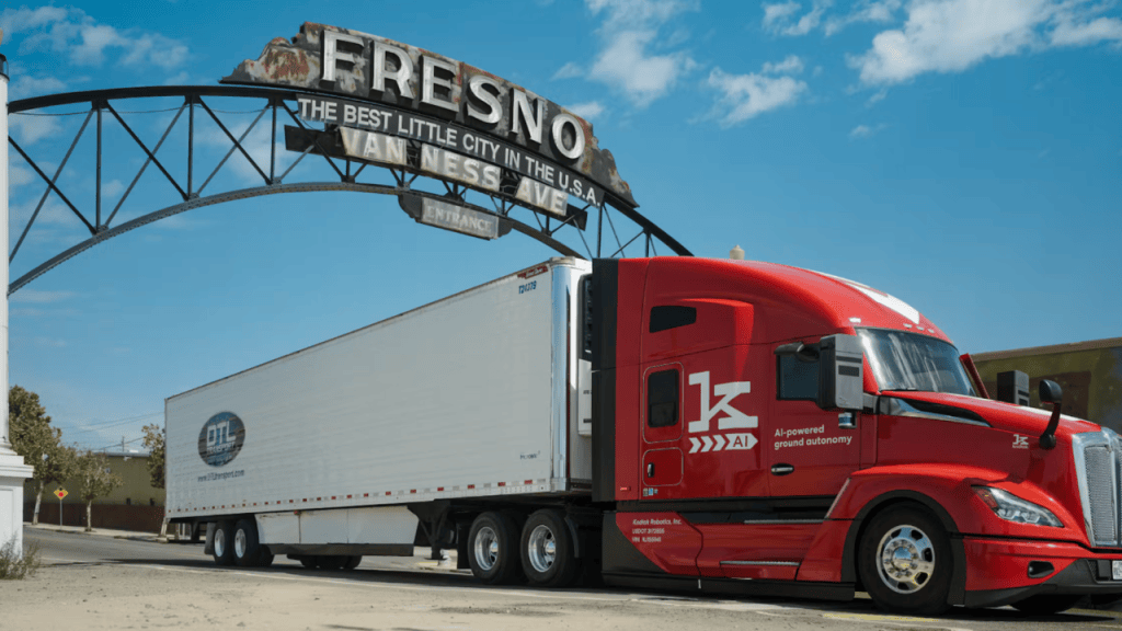 Red tractor-trailer equipped with the Kodiak Driver parked beneath the Fresno arch sign in Fresno, California